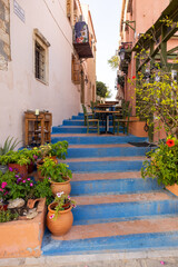 Fototapeta na wymiar Small narrow street with blue stairs in Old Town of Rethymnon, Crete island, Greece