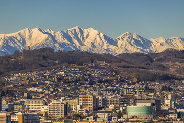 夕陽に照らされた北アルプスと松本市街地