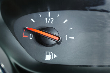 Naklejka premium Close up of a fuel gauge showing a nearly empty fuel tank in a car. Transportation with fossil fuel.