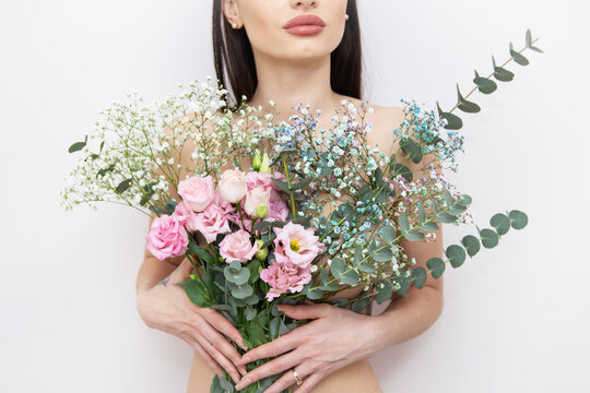 The girl's hands are holding a very beautiful spring bouquet of flowers: pink eustoma, gypsophila multicolored, eucalyptus. Flower composition. Spring, 8 March.