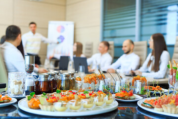 Catering in the office. A table with canapes and various snacks served  on the background of a...