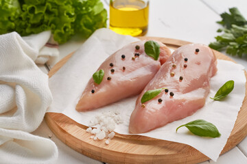 fresh raw chicken breast mix of pepper lettuce basil rock sea salt white wooden background