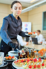 The waiter lays out food for catering.