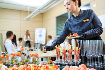 The waiter lays out food for catering.