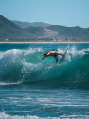 Surfer on turquoise water in Cerritos Beach, Todos Santos, Baja California 
