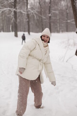 Two girls playing snowballs in the snow in the winter in a warm winter clothes