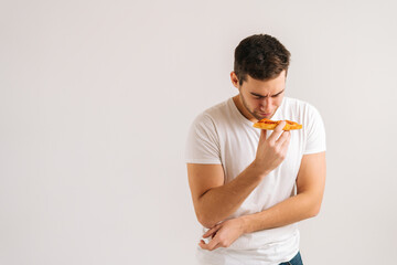 Portrait of sick upset young man feeling pain in stomach after eating pizza, suffering abdomen...