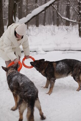 a girl in a white jacket playing with dogs