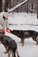 a girl in a white jacket playing with dogs