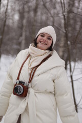 Obraz premium a girl with a camera on a winter walk in the woods