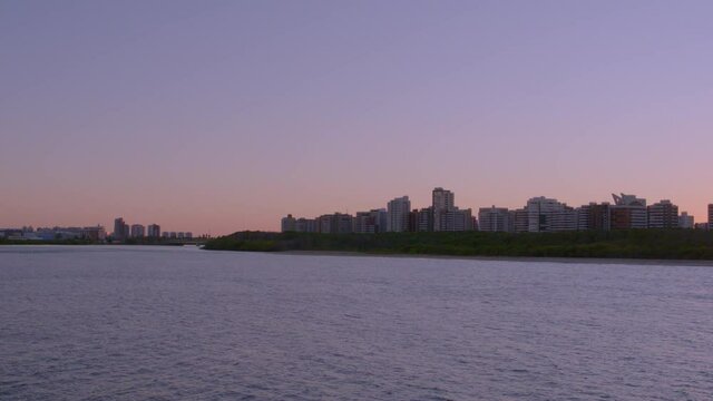 aerial view of the city of Aracaju in the state of Sergipe in Brazil with pan image from the left with buildings by the river at sunset
