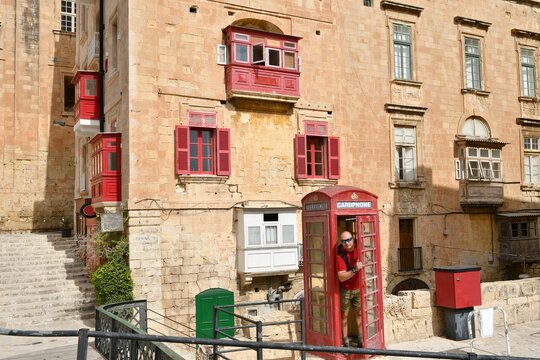 Man in traditional english red phone booth in Valletta, Malta