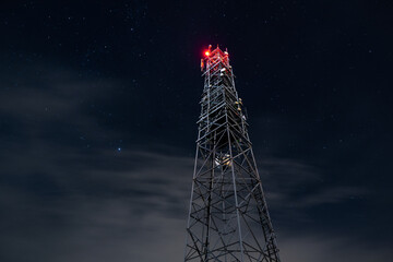 Tower for mobile communication systems 4g and 5g on the background of the starry sky. Cellular base...