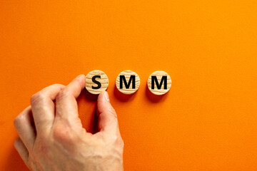 Fototapeta na wymiar SMM, social media marketing symbol. Concept word SMM social media marketing on wooden circles on beautiful orange background, copy space. Business, SMM social media marketing concept.