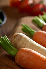 Carrots and a parsnip on a wooden cutting board