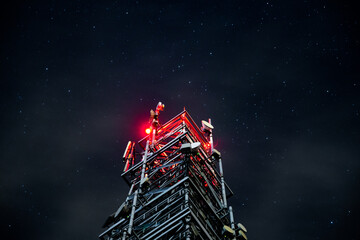Tower for mobile communication systems 4g and 5g on the background of the starry sky. Cellular base station at night