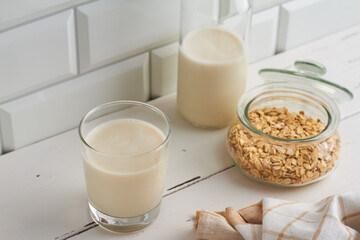 oat milk in a glass oat flakes milk bottle white background