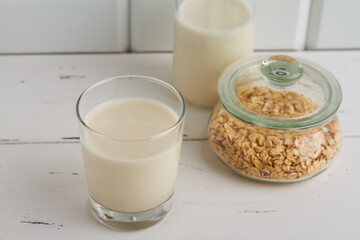 oat milk in a glass oat flakes milk bottle white background