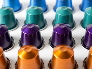 many aluminum coffee capsules are displayed in a row on a white background. Food pattern. Capsules for the coffee machine