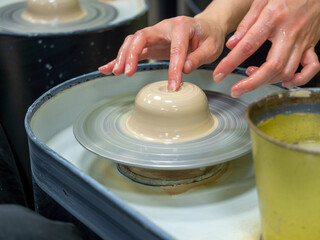 A close-up of a craftsman making an object out of clay on a potter's wheel. Handmade, hobby, hobby
