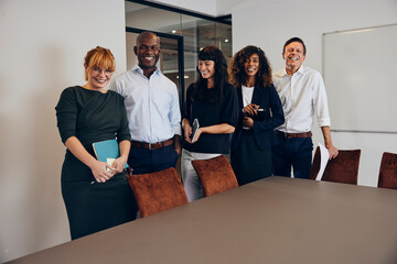 Laughing businesspeople standing in a boardroom