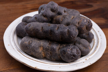 Colorful belgian purple or black truffle potato root vegetable