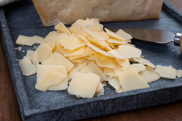 Flakes of parmesan cheese, italian hard parmigiano-reggiano cheese from Reggio Emilia region