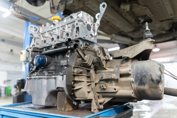 a gearbox mounted on a car engine stands on a workbench, under the car, close-up. selective focus