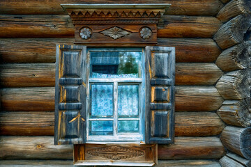 A windows in the wall of an old wooden house