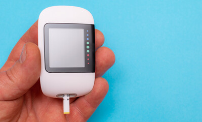 glucometer  on a blue background. electronic diagnostic device