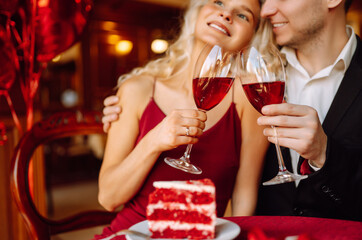 Valentine's Day concept. Exchange of gifts. Beautiful young couple celebrating Valentine's Day  in the restaurant. Hug, kiss and enjoy spending time together.