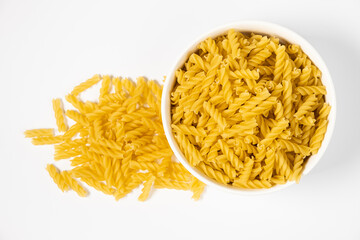 Close up of several types of dry pasta in a plate on white background