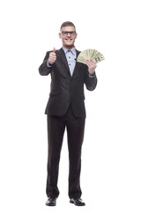 in full growth. happy young businessman with cash banknotes.
