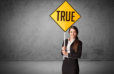 Young business person holding road sign