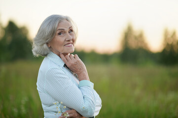 Fototapeta na wymiar Portrait of happy senior beautiful woman posing in spring park