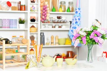 Fototapeta na wymiar Yellow tableware and flowers on a kitchen table
