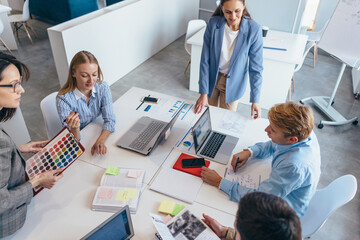 Group of businesspeople interacting with each other in an office