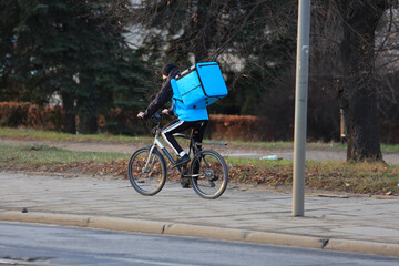 Kurier jedzie na rowerze we Wrocławiu, dostarcza jedzenie.  - obrazy, fototapety, plakaty