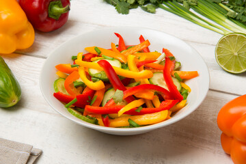Salad of bell pepper, cucumber on an old white table with ingredients. Selected focus.