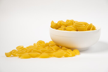 Close up of several types of dry pasta in a plate on white background