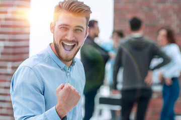 Handsome businessman celebrating victory shouting happily in th