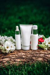 Natural Cosmetics set product. Ourdoors nature placement with grass, flowers and tree bark