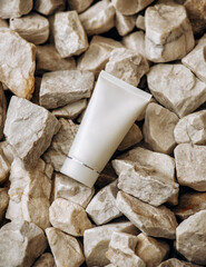 White cosmetic tube pack Of Cream Or Gel on stones. Sun cream