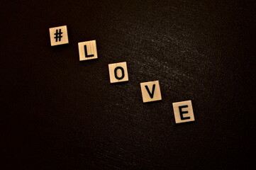 Letters arranged to write #love on a dark background. An important day for couples.