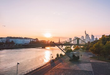 Aerial cityscape of Frankfurt am Main (Germany) from Wesseler Werft dock. Sunlit skyscrapers at sunset