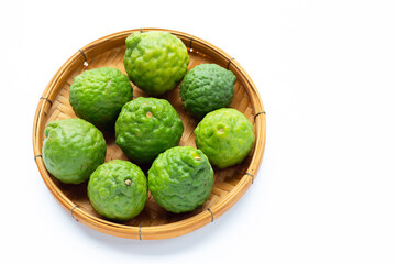 Fresh kaffir lime or bergamot fruit in bamboo basket on white background.