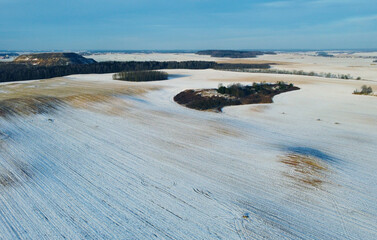 Fototapeta premium Top view photo of a winter suburban landscape with snowy fields, meadows and forests