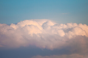 Nuage de type cumulonimbus de couleur rose pâle avec des zones plus sombres