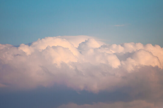 Nuage de type cumulonimbus de couleur rose p&acirc;le avec des zones plus sombres