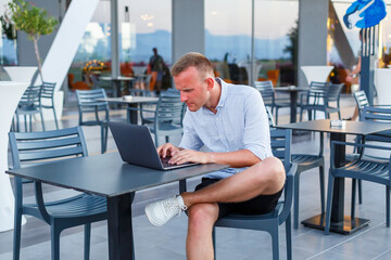 Successful male freelance businessman using laptop computer at work on vacation. Business, study, freelance. Remote work